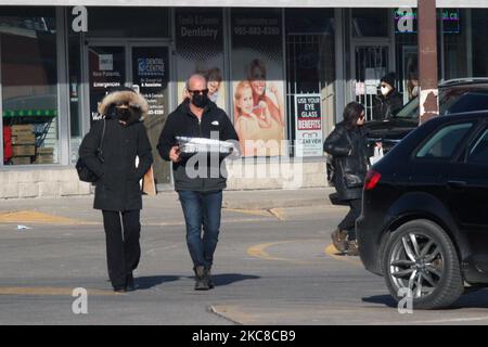 Menschen mit Gesichtsmasken während der neuartigen Coronavirus-Pandemie (COVID-19) am 09. Januar 2020 in Toronto, Ontario, Kanada. Neue COVID-19-Modelle und -Prognosen der Provinz Ontario sagen voraus, dass die hochansteckende Variante B.1.1.7 United Kingdom (UK) COVID-19 bis März 2021 zum dominanten Stamm in Ontario werden wird. Die neue hochansteckende britische Variante stellt eine erhebliche Bedrohung dar, da sie leichter mit menschlichen Zellen bindet als andere Varianten und etwa 60 Prozent mehr übertragbar ist als frühere Varianten und vermutlich tödlicher ist. (Foto von Creative to Stockfoto