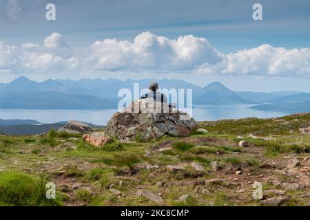 Applecross Peninsula, Highlands of Scotland, UK-Juli 28 2022: Ein Reisender und Wanderer, genießt die Mitte des Sommers Blick, von der Spitze des hohen Gebirgspass, OV Stockfoto