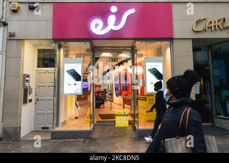 Menschen mit Gesichtsmasken kommen während der Covid-19-Sperre auf Ebene 5 am Eir-Laden im Stadtzentrum von Dublin vorbei. Am Samstag, den 30. Januar 2021, in Dublin, Irland. (Foto von Artur Widak/NurPhoto) Stockfoto