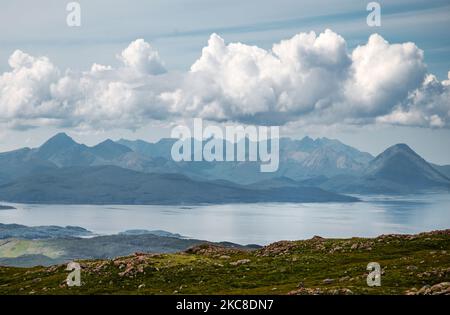 Über das ruhige Meer nach Skye, Sommerhimmel und flauschige Wolken, auf der Halbinsel Applecross, in Wester Ross, Schottische Highlands. Stockfoto