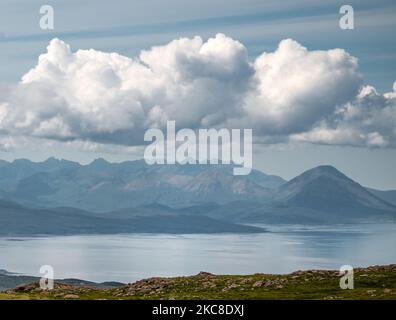 Über das ruhige Meer nach Skye, Sommerhimmel und flauschige Wolken, auf der Halbinsel Applecross, in Wester Ross, Schottische Highlands. Stockfoto