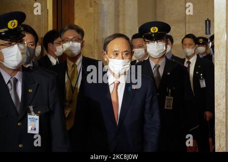 Japans Premierminister Yoshihide Suga geht mit Sicherheitsleuten im Parlamentsgebäude vor einer Diskussionssitzung über die Gesetzesentwürfe zur Einführung von Geldstrafen für Menschen und Unternehmen, die die Maßnahmen des Landes zur Beendigung der Pandemie im japanischen Unterhaus in Tokio, Japan, am 1. Februar 2021 nicht einhalten. (Foto von Jinhee Lee/NurPhoto) Stockfoto