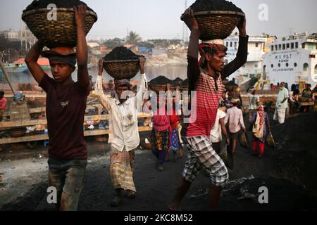 Arbeiter tragen Kohle auf Körben, als sie diese am Mittwoch, den 03. Februar 2021, von einem Frachtschiff am Ufer des Flusses Buriganga in Dhaka, Bangladesch, entladen. (Foto von Syed Mahamudur Rahman/NurPhoto) Stockfoto