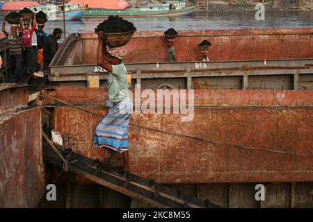 Arbeiter tragen Kohle auf Körben, als sie diese am Mittwoch, den 03. Februar 2021, von einem Frachtschiff am Ufer des Flusses Buriganga in Dhaka, Bangladesch, entladen. (Foto von Syed Mahamudur Rahman/NurPhoto) Stockfoto