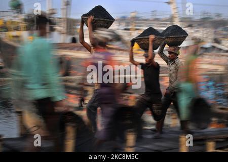 Arbeiter tragen Kohle auf Körben, als sie diese am Mittwoch, den 03. Februar 2021, von einem Frachtschiff am Ufer des Flusses Buriganga in Dhaka, Bangladesch, entladen. (Foto von Syed Mahamudur Rahman/NurPhoto) Stockfoto