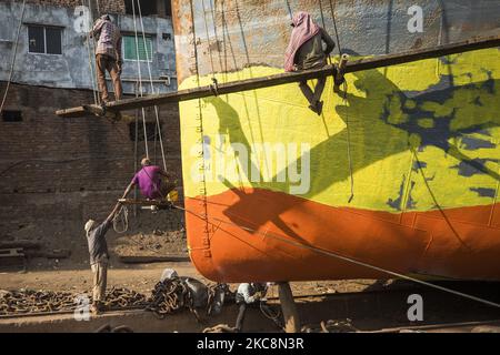 Hafenarbeiter führen am 4. Februar 2021 Wartungsarbeiten am Rumpf eines Schiffes am Ufer des Buriganga-Flusses in Dhaka, Bangladesch, durch. 28 Werften, die 30,96 Hektar des Buriganga-Vorhores besetzen, sind in den letzten 50 Jahren ohne Genehmigung oder Richtlinien in Betrieb, verschmutzen den Fluss und greifen in das Flussufer ein, was seine Schiffbarkeit verringert. (Foto von Ahmed Salahuddin/NurPhoto) Stockfoto