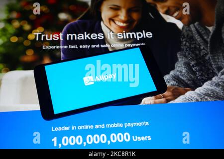 Das Alipay App-Logo wird auf einem Handybildschirm mit Alipay-Website-Hintergrund angezeigt. Krakau, Polen, am 5. Februar 2021. Die chinesische Alipay-App hat mehr als 700 Millionen monatliche Nutzer, die sie verwenden, um zu bezahlen, Kredite aufzunehmen, zu versichern und ihr Geld zu verwalten. (Foto-Illustration von Beata Zawrzel/NurPhoto) Stockfoto