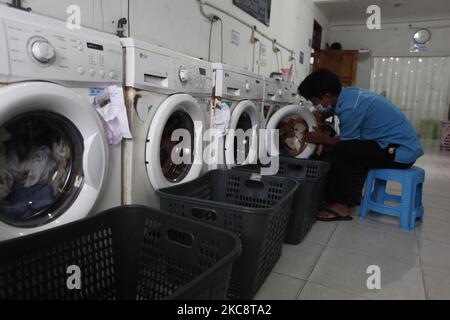 Ein Mitarbeiter lädt am 6. Februar 2021 Wäsche in eine Waschmaschine bei Bogor Laundry in Bogor, West Java. Bogor's Laundry ist ein gewerblicher Wäscheservice für Hotels, Industriebetriebe, Häuser. Die COVID-19-Pandemie hat den Wäschereisektor in der nationalen und globalen Wirtschaft noch nie getroffen. (Foto von Adriana Adie/NurPhoto) Stockfoto