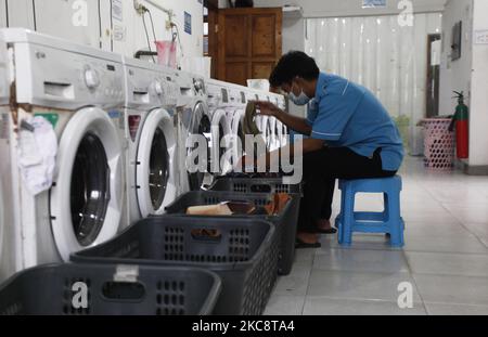 Ein Mitarbeiter lädt am 6. Februar 2021 Wäsche in eine Waschmaschine bei Bogor Laundry in Bogor, West Java. Bogor's Laundry ist ein gewerblicher Wäscheservice für Hotels, Industriebetriebe, Häuser. Die COVID-19-Pandemie hat den Wäschereisektor in der nationalen und globalen Wirtschaft noch nie getroffen. (Foto von Adriana Adie/NurPhoto) Stockfoto