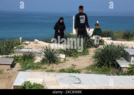 Die Mutter und der Bruder Mohammad, eines der vier Kinder der Großfamilie Bakr, die während des israelisch-palästinensischen Konflikts von 2014 getötet wurden, besuchen am 7. Februar 2021 das Grab des Opfers im al-Shati-Flüchtlingslager in Gaza-Stadt. Der Bruder überlebte mit Verletzungen am Tag des Tötens der vier Kinder.- das Urteil des Internationalen Strafgerichtshofs, dass er israelische Militärverletzungen in den besetzten palästinensischen Gebieten untersuchen kann und dazu aufruft, die Bemühungen um Gerechtigkeit zu beschleunigen. (Foto von Majdi Fathi/NurPhoto) Stockfoto