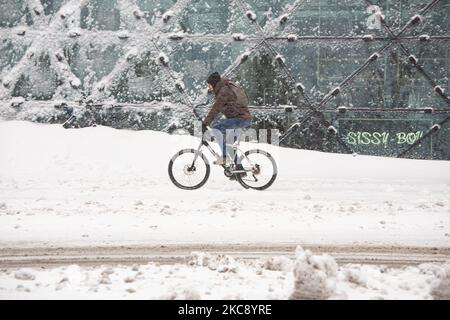 Im schneebedeckten Stadtzentrum von Eindhoven werden die Menschen am 18. Septemberplein mit ihrem Fahrrad auf dem Schnee fahren sehen. Blizzard vom Schneesturm Darcy in den Niederlanden, dem ersten starken Schneefall mit starken Winden nach 2010, der den Transport im ganzen Land störte. Die Niederländer erwachten am Sonntag mit einer Schneeschicht, die alles bedeckte. Viele Unfälle ereigneten sich auf den Straßen aufgrund des Sturms und der eisigen Bedingungen, während es auch Probleme mit den Zügen gab. In der Stadt Eindhoven in Nordbrabant wurde der Bahn- und Busverkehr eingestellt, der Flughafen folgte und der Luftverkehr umgeleitet Stockfoto