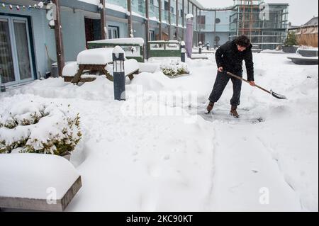 Ein Mann entfernt während des Schneesturms Darcy in Nijmegen am 8.. Februar 2021 den Schnee von seiner Haustür. (Foto von Romy Arroyo Fernandez/NurPhoto) Stockfoto