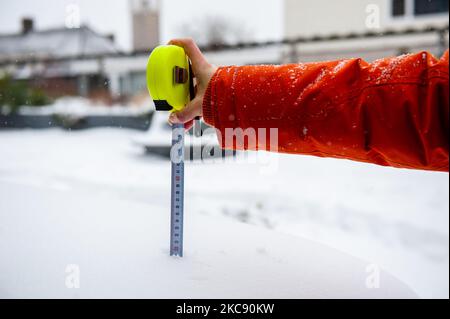 Ein Maßband zeigt die Zentimeter des Schnees, der sich während des Schneesturms Darcy in Nijmegen am 8.. Februar 2021 über einer Holzbank angesammelt hat. (Foto von Romy Arroyo Fernandez/NurPhoto) Stockfoto