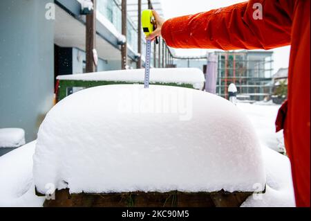 Ein Maßband zeigt die Zentimeter des Schnees, der sich während des Schneesturms Darcy in Nijmegen am 8.. Februar 2021 über einer Holzbank angesammelt hat. (Foto von Romy Arroyo Fernandez/NurPhoto) Stockfoto