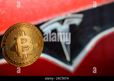 Illustrative Abbildung einer Gedenkmünze vor dem Tesla-Auto-Logo. Tesla, angeführt von Elon Musk, bestätigte, dass es im Januar rund 1,5 Milliarden Dollar an Bitcoin gekauft hatte und erwartet, dass es in Zukunft als Zahlung akzeptiert werden wird. Am Montag, den 8. Februar 2021, in Dublin, Irland. (Foto von Artur Widak/NurPhoto) Stockfoto