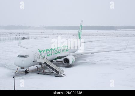 Geerdete Transavia-Flotte, Boeing 737 am Flughafen Eindhoven aufgrund des Schnees. Schneesturm schließt den Flughafen Eindhoven EIN in den Niederlanden. Starker Schneefall stört den Flugverkehr, der am Sonntag zu Umleitungen nach Deutschland führte. Blizzard vom Sturm Darcy traf das Land seit Sonntagmorgen (07.02.2021), was zu Problemen bei den öffentlichen Verkehrsmitteln führte. Auf dem schneebedeckten Flughafen Eindhoven werden Transavia-Flugzeuge am Boden gesehen, während schwere Maschinen die Rollbahn und die Landebahn reinigen. Dutzende von Flügen, die abfliegen sollten, wurden am Flughafen Schiphol in Amsterdam aufgrund der ar verspätet oder gestrichen Stockfoto