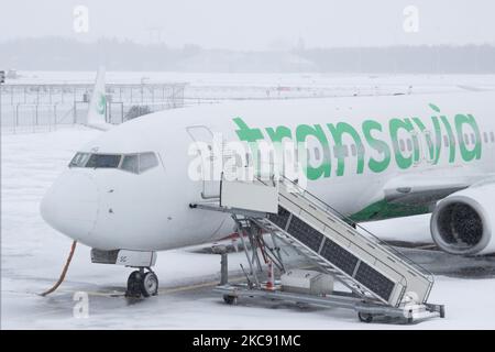 Geerdete Transavia-Flotte, Boeing 737 am Flughafen Eindhoven aufgrund des Schnees. Schneesturm schließt den Flughafen Eindhoven EIN in den Niederlanden. Starker Schneefall stört den Flugverkehr, der am Sonntag zu Umleitungen nach Deutschland führte. Blizzard vom Sturm Darcy traf das Land seit Sonntagmorgen (07.02.2021), was zu Problemen bei den öffentlichen Verkehrsmitteln führte. Auf dem schneebedeckten Flughafen Eindhoven werden Transavia-Flugzeuge am Boden gesehen, während schwere Maschinen die Rollbahn und die Landebahn reinigen. Dutzende von Flügen, die abfliegen sollten, wurden am Flughafen Schiphol in Amsterdam aufgrund der ar verspätet oder gestrichen Stockfoto