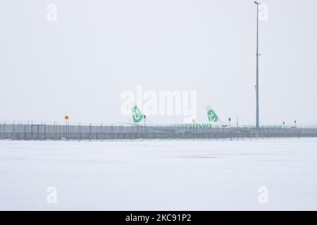 Geerdete Transavia-Flotte, Boeing 737 am Flughafen Eindhoven aufgrund des Schnees. Schneesturm schließt den Flughafen Eindhoven EIN in den Niederlanden. Starker Schneefall stört den Flugverkehr, der am Sonntag zu Umleitungen nach Deutschland führte. Blizzard vom Sturm Darcy traf das Land seit Sonntagmorgen (07.02.2021), was zu Problemen bei den öffentlichen Verkehrsmitteln führte. Auf dem schneebedeckten Flughafen Eindhoven werden Transavia-Flugzeuge am Boden gesehen, während schwere Maschinen die Rollbahn und die Landebahn reinigen. Dutzende von Flügen, die abfliegen sollten, wurden am Flughafen Schiphol in Amsterdam aufgrund der ar verspätet oder gestrichen Stockfoto