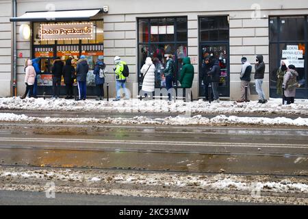 In der Bäckerei „Dobra Paczkarnia“ stehen die Leute am Fat Thursday Schlange, um Donuts zu kaufen. Krakau, Polen am 11. Januar 2021. Fat Thursday ist ein traditionelles katholisches christliches Fest am letzten Donnerstag vor der Fastenzeit. Es symbolisiert die Feier des Karnevals. Das beliebteste Gericht, das an diesem Tag in Polen serviert wird, sind Paczki - faustgroße Donuts, gefüllt mit Marmelade. (Foto von Beata Zawrzel/NurPhoto) Stockfoto