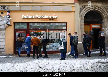 In der Bäckerei „Dobra Paczkarnia“ stehen die Leute am Fat Thursday Schlange, um Donuts zu kaufen. Krakau, Polen am 11. Januar 2021. Fat Thursday ist ein traditionelles katholisches christliches Fest am letzten Donnerstag vor der Fastenzeit. Es symbolisiert die Feier des Karnevals. Das beliebteste Gericht, das an diesem Tag in Polen serviert wird, sind Paczki - faustgroße Donuts, gefüllt mit Marmelade. (Foto von Beata Zawrzel/NurPhoto) Stockfoto