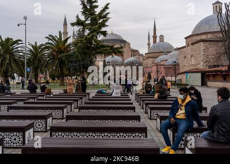 Die Menschen ruhen am Standort der neu umgebauten Hagia Sophia-Moschee in Istanbul, Türkei, die am 11. Februar 2021 gesehen wurde. Im Rahmen der Maßnahmen gegen die Verbreitung von COVID-19 bieten Restaurants und Cafés nur Take-away- und Lieferservice an, und die Menschen bevorzugen es, sich an öffentlichen Plätzen oder an den historischen Denkmälern der Stadt zu unterhalten. (Foto von Erhan Demirtas/NurPhoto) Stockfoto