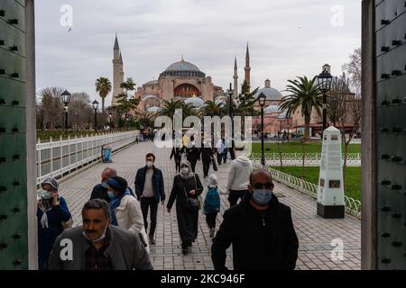 Besucher der Sultanahmet (Blaue) Moschee in Istanbul, Türkei, gesehen am 11. Februar 2021 mit der neu umgebauten Hagia Sophia große Moschee im Hintergrund. Im Rahmen der Maßnahmen gegen die Verbreitung von COVID-19 bieten Restaurants und Cafés nur Take-away- und Lieferservice an, und die Menschen bevorzugen es, sich an öffentlichen Plätzen oder an den historischen Denkmälern der Stadt zu unterhalten. (Foto von Erhan Demirtas/NurPhoto) Stockfoto