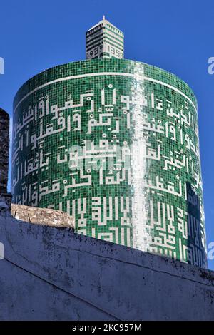 Zylindrisches Minarett der Sentissi-Moschee in der Stadt Moulay Idriss (Moulay Idriss Zerhoun) in Marokko, Afrika. Die Sentissi-Moschee wurde 1939 von einem Einheimischen nach seiner Rückkehr von der Hadsch-Wallfahrt in Mekka erbaut. Es hat das einzige zylindrische Minarett in Marokko. Das Minarett ist mit grünen Kacheln mit weißen arabischen Buchstaben im Kufic-Stil bedeckt, die eine Sure aus dem Koran ausweisen. Die Moschee ist heute eine koranische Schule (madrasa) und wird auch als Medersa Idriss bezeichnet. Die heilige Stadt Moulay Idriss war der Ort, an dem Moulay Idriss 789 ankam und die Religion von mir mitbrachte Stockfoto