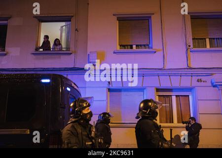 Nachbarn schauen aus ihrem Fenster auf die Antiriot-Agenten der Mossos de Equadra und versuchen, einen Mann zu stoppen, der nach der Wahlkampfveranstaltung der Vox-Fraktion am 12. Februar 2021 auf der Plaza Artos, Barcelona, Spanien, von Vox-Anhängern angegriffen wurde. (Foto von Pau de la Calle/NurPhoto) Stockfoto