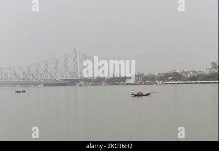 Ein Boot kann auf dem Fluss Ganga mit der Howrah-Brücke im Hintergrund in Kalkutta, Inidia, 13. Februar 2021 sein. (Foto von Indranil Aditya/NurPhoto) Stockfoto