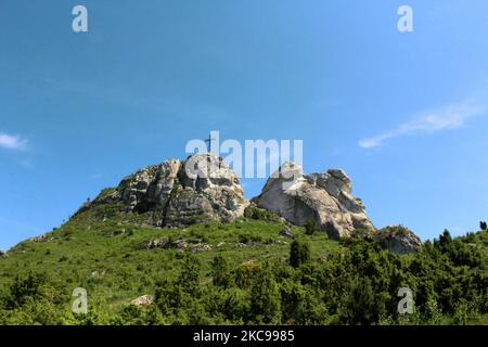 Der Maly Giewont Berg mit einem Kreuz auf der Spitze, umgeben von viel Grün Stockfoto