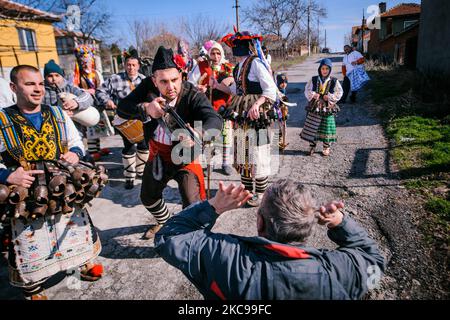 Pobeda Village, Yambol. Bulgarien. Männer, die als unheimliche Kreaturen verkleidet sind, gehen durch das Dorf Pobeda, Bezirk Yambol, Bulgarien, um Häuser zu besuchen und die bösen Geister zu vertreiben. Die alte bulgarische Tradition von Kuker wurde in der Zeit zwischen Winter und Frühling, zu Beginn des neuen Landwirtschaftsjahres, durchgeführt. Die Masken sind einzigartig für jede Region des Landes, aber in der Regel mit großen Glocken, bunten Textilien und Tierfellen. Es gibt Rollen unter den Kuker-Gruppen wie der Ältere, die Braut, der Arzt, der Bär und so weiter. Die „Kuker“ schlugen symbolisch die Hausbesitzer mit Stockfoto