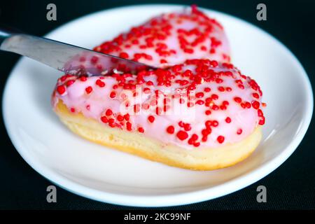 Ein in zwei Teile geschnittener herzförmiger Donut ist als Illustration des Valentinstag abgebildet. Krakau, Polen, am 14. Februar 2021. (Foto von Beata Zawrzel/NurPhoto) Stockfoto