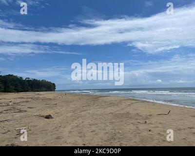 Ein Sandstrand am blauen Himmel mit schwebenden Wolken in Punta Uva, Puerto Viejo, Costa Rica Stockfoto