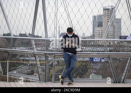 Ein Iraner benutzt sein Smartphone, während er am 16. Februar 2021 im Wasser- und Feuerpark im Norden Teherans auf einer Brücke steht, die mit einem Huawei 5G-Modem ausgestattet ist. Irans erstes 5G-Netz wurde von der Firma Irancell betrieben, einem iranischen Telekommunikationsunternehmen, das Irans größtes 2G-3G-4G-4,5G betreibt, das auch 5G Mobilfunknetze und feste drahtlose TD-LTE-Internetdienste betreibt. (Foto von Morteza Nikoubazl/NurPhoto) Stockfoto