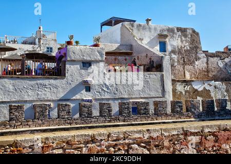 Restaurants und Cafés an den alten Festungsmauern in der Küstenstadt Essaouira, Marokko, Afrika. Essaouira ist eine Hafenstadt und ein Ferienort an der marokkanischen Atlantikküste. Die Medina (Altstadt) wird von den Küstenwällen aus dem 18.. Jahrhundert geschützt, die als Skala de la Kasbah bezeichnet werden und von europäischen Ingenieuren entworfen wurden. Alte Messingkanonen säumen die Wände, und es gibt Meerblick. (Foto von Creative Touch Imaging Ltd./NurPhoto) Stockfoto