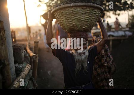 Ein Arbeiter reagiert auf die Kamera, als er am Donnerstag, den 18. Februar 2021, Kohle von einem Frachtschiff neben dem Buriganga River in Dhaka, Bangladesch, entlädt. (Foto von Syed Mahamudur Rahman/NurPhoto) Stockfoto