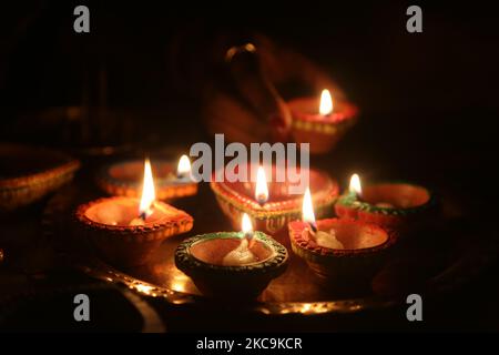 Hindu-Anhänger halten eine Diya (kleine Tonlampe) während des Festivals von Diwali in einem Hindu-Tempel in Toronto, Ontario, Kanada, am 14. November 2020. (Foto von Creative Touch Imaging Ltd./NurPhoto) Stockfoto