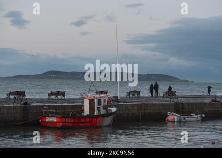 Die Menschen beobachten das Meer in der Abenddämmerung vom Hafen Bullock in der Nähe von Dun Laoghaire während der Covid-19-Sperre auf Level 5. Am Samstag, den 20. Februar 2021, fand in Dún Laoghaire, Dublin, Irland. (Foto von Artur Widak/NurPhoto) Stockfoto