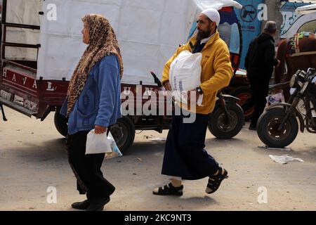 Ein Palästinenser trägt am 21. Februar 2021 in einem Verteilungszentrum im Lager Shati für palästinensische Flüchtlinge in Gaza-Stadt Nahrungsmittelhilfe des UNRWA (United Nations Relief Works Agency). (Foto von Majdi Fathi/NurPhoto) Stockfoto