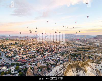 Bunte Heißluftballons fliegen über das Tal der Feenkamine in Nevsehir, Goreme, Kappadokien, Türkei. Spektakuläre Panorama Drohne Blick auf die unterirdische Stadt und Ballonfahrten Tourismus. Hochwertige Fotos Stockfoto