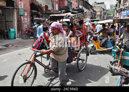 Schulkinder reisen in einer überflutete Rikscha entlang einer belebten Straße auf dem Chandni Chowk Market in Alt-Delhi, Indien. Chandni Chowk ist Asiens größter Großhandelsmarkt. Die Legende besagt, dass der Moghul-Kaiser Shah Jahan Chandni Chowk im 17.. Jahrhundert plante, damit seine Tochter alles kaufen konnte, was sie wollte. Chandni Chowk, also ein mondlichter Platz oder Markt, bleibt eine der belebtesten, chaotischsten und berühmtesten Gegenden der Stadt. (Foto von Creative Touch Imaging Ltd./NurPhoto) Stockfoto