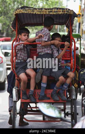 Schulkinder reisen in einer überflutete Rikscha entlang einer belebten Straße auf dem Chandni Chowk Market in Alt-Delhi, Indien. Chandni Chowk ist Asiens größter Großhandelsmarkt. Die Legende besagt, dass der Moghul-Kaiser Shah Jahan Chandni Chowk im 17.. Jahrhundert plante, damit seine Tochter alles kaufen konnte, was sie wollte. Chandni Chowk, also ein mondlichter Platz oder Markt, bleibt eine der belebtesten, chaotischsten und berühmtesten Gegenden der Stadt. (Foto von Creative Touch Imaging Ltd./NurPhoto) Stockfoto