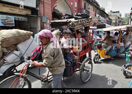 Schulkinder reisen in einer überflutete Rikscha entlang einer belebten Straße auf dem Chandni Chowk Market in Alt-Delhi, Indien. Chandni Chowk ist Asiens größter Großhandelsmarkt. Die Legende besagt, dass der Moghul-Kaiser Shah Jahan Chandni Chowk im 17.. Jahrhundert plante, damit seine Tochter alles kaufen konnte, was sie wollte. Chandni Chowk, also ein mondlichter Platz oder Markt, bleibt eine der belebtesten, chaotischsten und berühmtesten Gegenden der Stadt. (Foto von Creative Touch Imaging Ltd./NurPhoto) Stockfoto