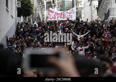 Algerier halten eine Nationalflagge mit der arabischen Inschrift, die die Erwähnung trägt, während sie zum zweiten Jahrestag der Volksproteste in Algier, Algerien, am 22. Februar 2021 marschieren. Algerien feiert den zweiten Jahrestag der Bewegung am 22. Februar 2021 Massenprotest, bekannt als Hirak, der zum Rücktritt des damaligen Präsidenten Abdelaziz Bouteflika führte. Der amtierende algerische Präsident Abdelmadjid Tebbounne kündigte am 18. Februar die Begnadigung und Freilassung von etwa sechzig Personen an, die aufgrund ihrer Beteiligung an der Hirak-Protestbewegung verurteilt oder auf ein Gerichtsverfahren warten. Er sagte auch, dass er es war Stockfoto