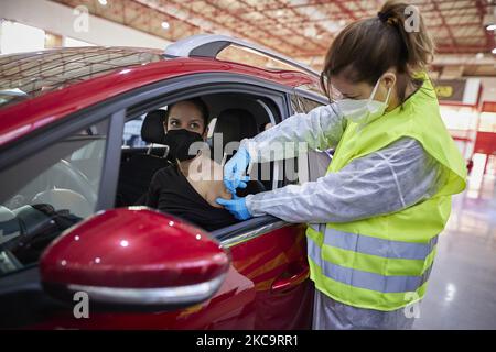 Eine Gesundheitsarbeiterin mit Handschuhen verabreicht einer Frau in ihrem Auto den Impfstoff AstraZeneca Covid-19 während der Impfung von Lehrern und Lehrkräften in den Armilla-Messepavillons am 22. Februar 2021 in Armilla (Granada, Spanien). Die andalusische Regionalregierung beginnt mit der Impfung gegen Covid-19 mit Impfstoffen von AstraZeneca, die in den 10.000 Bildungsfachkräften und Lehrern im Bezirk Granada zentralisiert werden. (Foto von Fermin Rodriguez/NurPhoto) Stockfoto