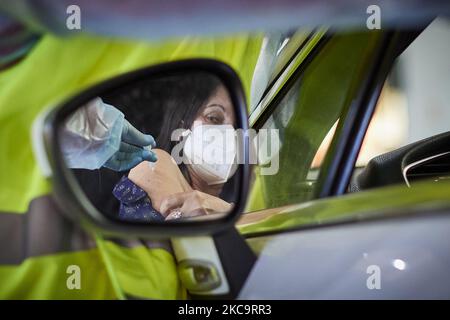 Eine Gesundheitsarbeiterin mit Handschuhen verabreicht einer Frau in ihrem Auto den Impfstoff AstraZeneca Covid-19 während der Impfung von Lehrern und Lehrkräften in den Armilla-Messepavillons am 22. Februar 2021 in Armilla (Granada, Spanien). Die andalusische Regionalregierung beginnt mit der Impfung gegen Covid-19 mit Impfstoffen von AstraZeneca, die in den 10.000 Bildungsfachkräften und Lehrern im Bezirk Granada zentralisiert werden. (Foto von Fermin Rodriguez/NurPhoto) Stockfoto