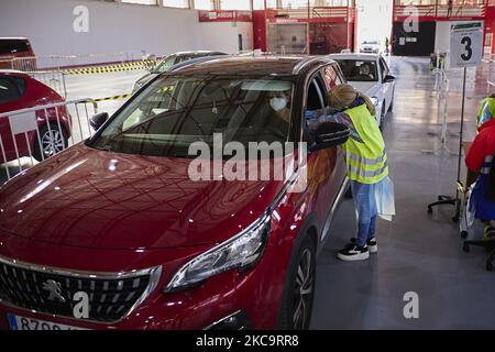 Eine Gesundheitsarbeiterin mit Handschuhen verabreicht einer Frau in ihrem Auto den Impfstoff AstraZeneca Covid-19 während der Impfung von Lehrern und Lehrkräften in den Armilla-Messepavillons am 22. Februar 2021 in Armilla (Granada, Spanien). Die andalusische Regionalregierung beginnt mit der Impfung gegen Covid-19 mit Impfstoffen von AstraZeneca, die in den 10.000 Bildungsfachkräften und Lehrern im Bezirk Granada zentralisiert werden. (Foto von Fermin Rodriguez/NurPhoto) Stockfoto