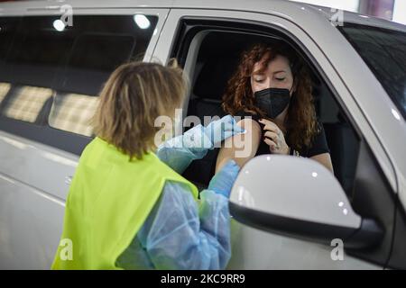 Eine Gesundheitsarbeiterin mit Handschuhen verabreicht einer Frau in ihrem Auto den Impfstoff AstraZeneca Covid-19 während der Impfung von Lehrern und Lehrkräften in den Armilla-Messepavillons am 22. Februar 2021 in Armilla (Granada, Spanien). Die andalusische Regionalregierung beginnt mit der Impfung gegen Covid-19 mit Impfstoffen von AstraZeneca, die in den 10.000 Bildungsfachkräften und Lehrern im Bezirk Granada zentralisiert werden. (Foto von Fermin Rodriguez/NurPhoto) Stockfoto