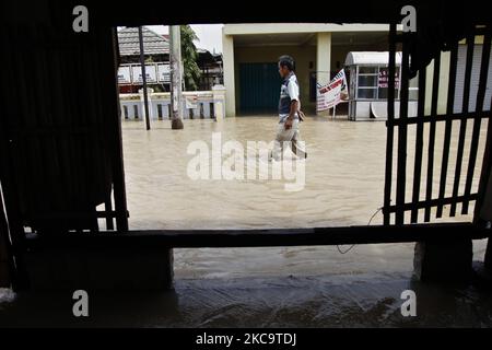 Bewohner, die am 22. Februar 2021 die Überschwemmungen im Teilbezirk Pebayuran, Bekasi-Regentschaft, West-Java, überquerten. Massive Überschwemmungen trafen eine Reihe von Dörfern in Bekasi Regentschaft, West-Java, nach starken Regenfällen, die in den letzten Tagen auftraten und einen Überlauf des Flusses Cibeet verursachten und den Citarum-Damm platzten. Mindestens 6,000 Familien waren von dieser Katastrophe betroffen. (Foto von Aditya Irawan/NurPhoto) Stockfoto