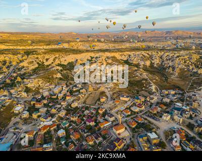 Atemberaubende Drohnenansicht von Hunderten von Heißluftballons, die während des Sonnenaufgangs über die ikonische Kappadokien der Türkei fahren, die Stadt inmitten des Tals der Feenkamine. Hochwertige Fotos Stockfoto